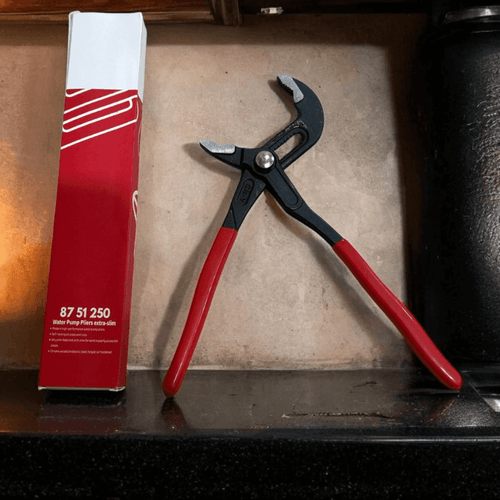 Water Pump Pliers with ergonomic handles displayed alongside packaging on a countertop.